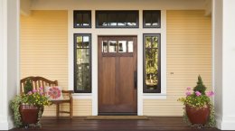 A house's door with an angled bench and two large flower pots