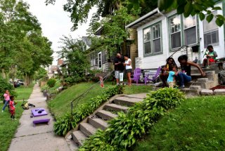 Andrea Giles, center in white, a corrections officer with Ramsey County, hosts her family and neighbors on her recently spruced up front yard in an effort to get people to know their Rondo area neighbors on Wednesday, August 17, 2016. The Knight Foundation provided Giles with a small grant to help her make her front yard more inviting. (Pioneer Press: John Autey)