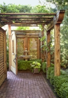 arched wood garden gate brick path