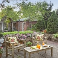 back yard lounge area conical dwarf Alberta spruces, serviceberry trees, coleus, impatiens, vining mandevilla