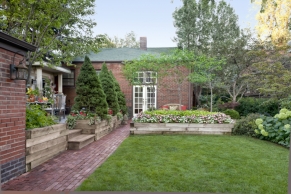 backyard brick path separates lawn and lounge from dining deck