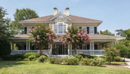 Crepe myrtles bloom in front of a house